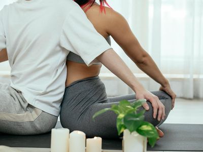 Soft light hitting a person back in yoga pose
